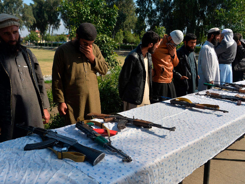 مقاتلون سابقون من «طالبان» يسلّمون أسلحتهم للقوات الأمنية الأفغانية في جلال آباد أمس (أ ف ب)