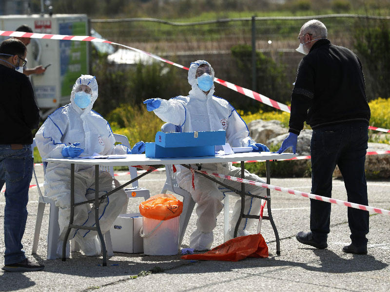 نقطة اقتراع في الهواء الطلق بإجراءات طبية خوفاً من «كورونا» في حيفا أمس (أ ف ب)