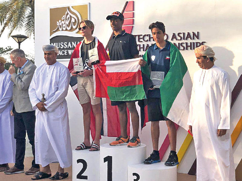 لاعب المنتخب الوطني للشراع علي الفيلكاوي على منصة التتويج مع الفارسي وإيرك