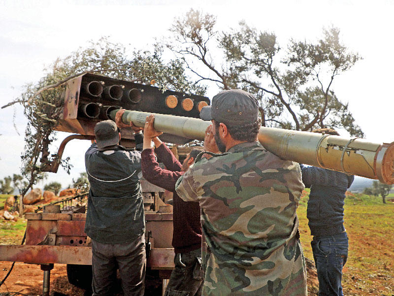 مقاتلون موالون لتركيا يجهِّزون قاذفة صواريخ  في إدلب أمسt(أ ف ب)