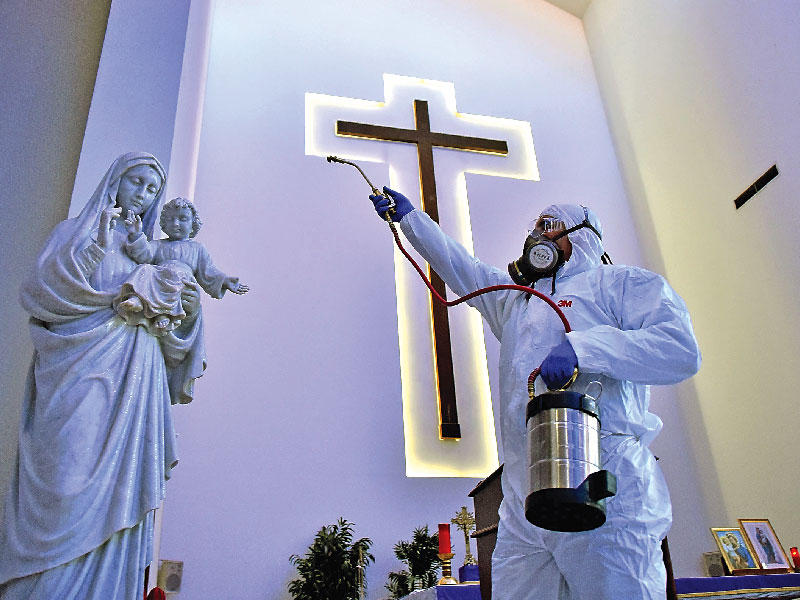عامل لبناني يعقم كنيسة في بيروت أمس (رويترز)