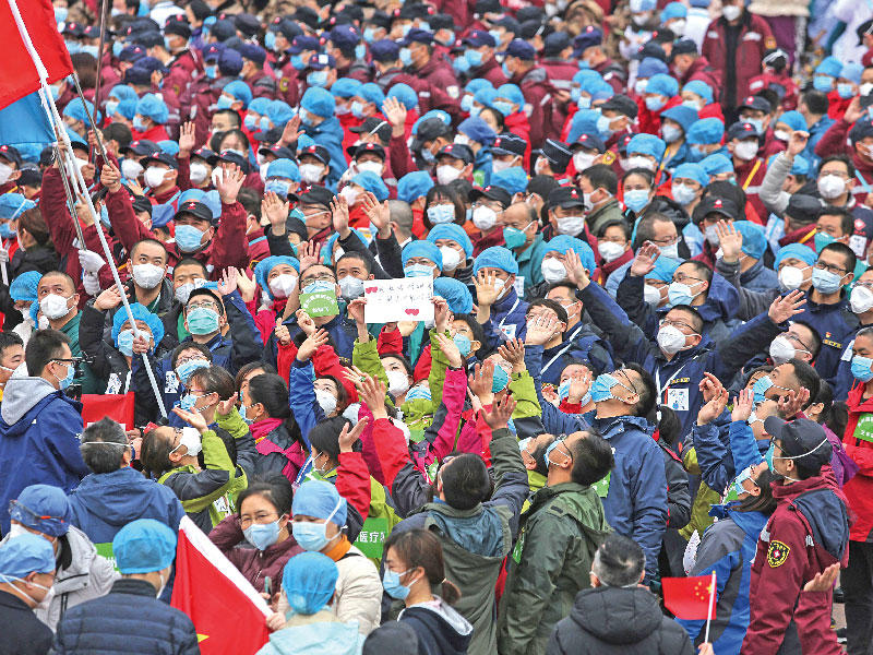 ممرضون في مستشفى ووهان الصيني يحتفلون بعد مغادرة آخر المصابين بالفيروس أمس (ا ف ب)
