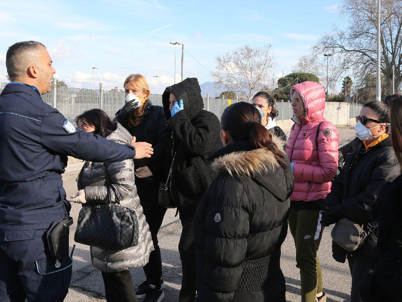 حراس السجن يتحدثون  مع أقارب السجناء المجتمعين لمنع حركة المرور أثناء احتجاجهم على التدابير بما في ذلك فرض حظر على الزيارات العائلية