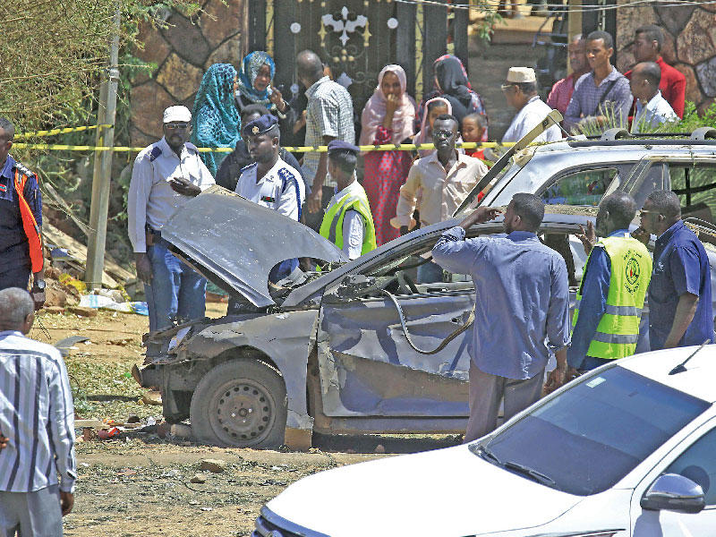 رجال الأدلة الجنائية وعناصر أمنية بمحيط سيارة تضررت جراء الهجوم الذي تعرض له موكب حمدوك في الخرطوم أمس    (أ ف ب)