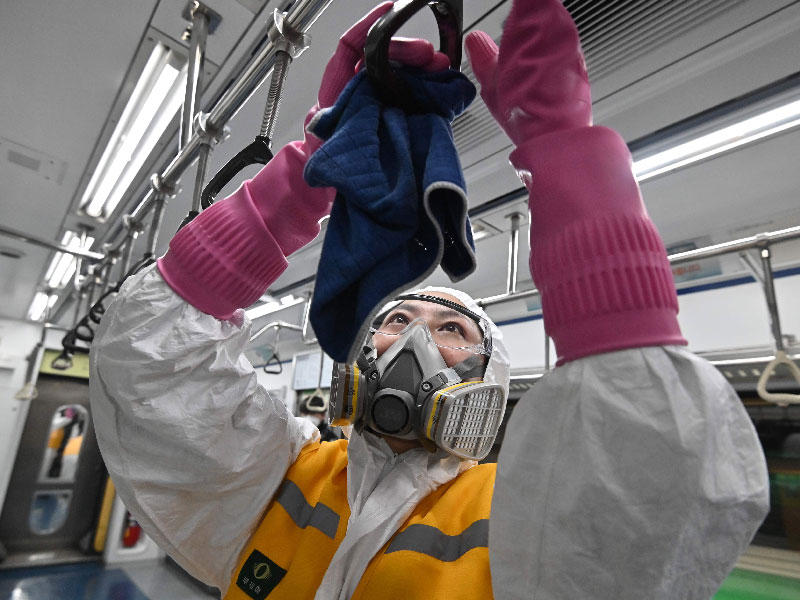 عامل  يقوم بتطهير قطار للمساعدة في منع انتشار الفيروس التاجي ، في محطة مترو مترو سيول