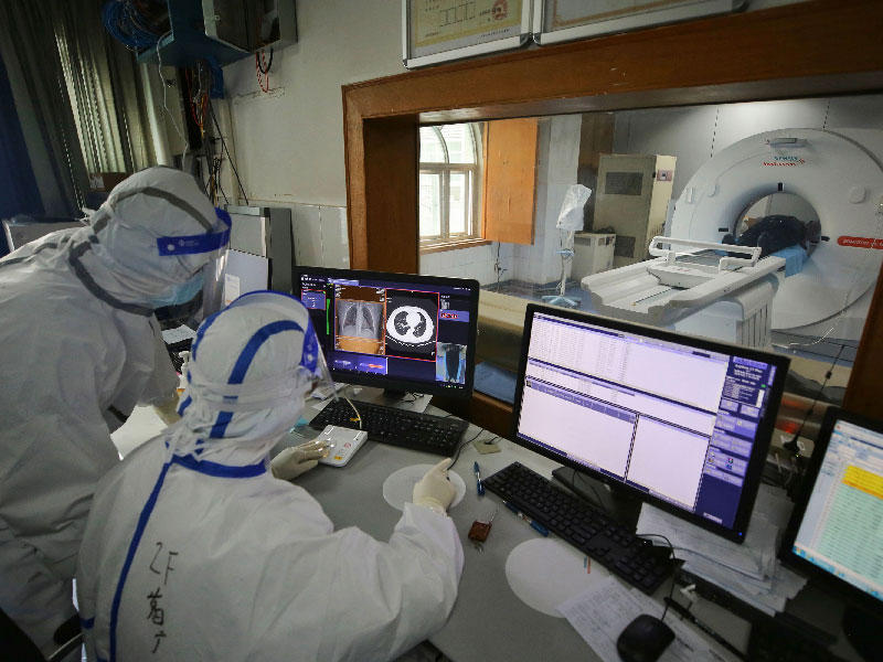يقوم الطاقم الطبي بإجراء مسح بالأشعة المقطعية لمريض مصاب بفيروس التاجي في مستشفى الصليب الأحمر في ووهان