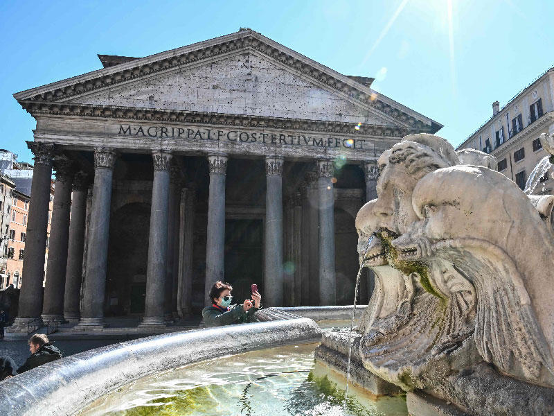 امرأة ترتدي قناعًا واقعيًا تلتقط صورة سيلفي خارج نصب بانثيون المغلق في وسط روما