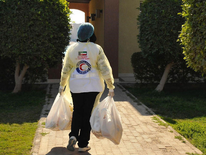 احدى المتطوعات تقوم بتوصيل المستلزمات الغذائية لحد المواطنين المحجورين في منتزه الخيران