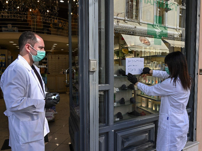 «ليس لدينا كمامات ولا معقمات» هكذا كتب على ورقة تقوم عاملة بإحدى صيدليات أثينا بلصقها على واجهة الصيدلية أمس (أ ف ب) 