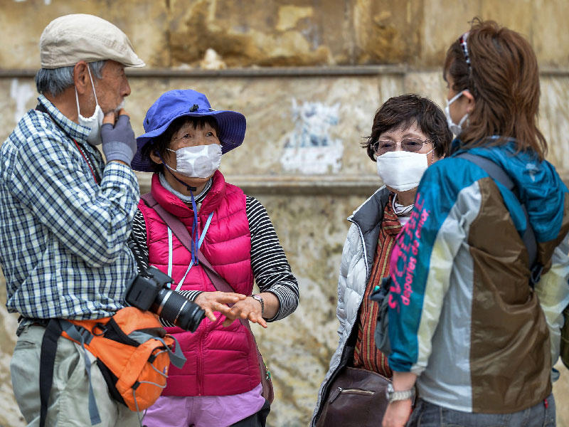 سائحون يرتدون أقنعة واقية واقية خارج مسجد الحسين في منطقة القاهرة الإسلامية