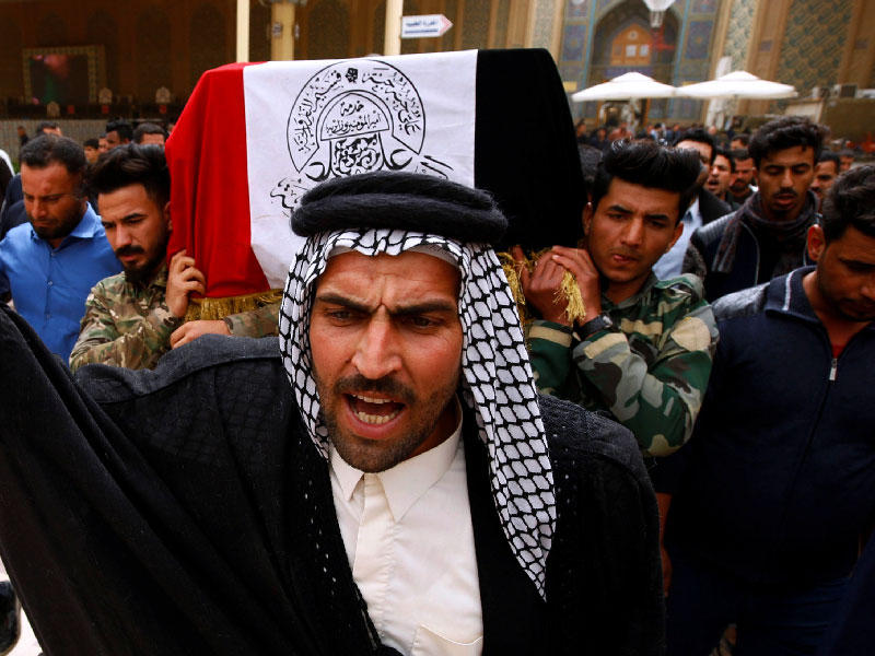 عراقيون يشيعون أحد قتلى الغارات الأميركية في النجف أمس (رويترز)