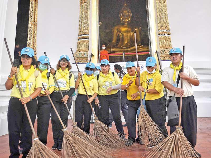 متطوّعون تايلنديون  يشاركون في حملة نظافة وتعقيم أحد معابد بانكوك أمس (ا ف ب)  
