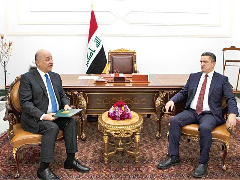 الرئيس العراقي برهم صالح مستقبلاً الزرفي لتكليفه في قصر السلام ببغداد  (أ ف ب)