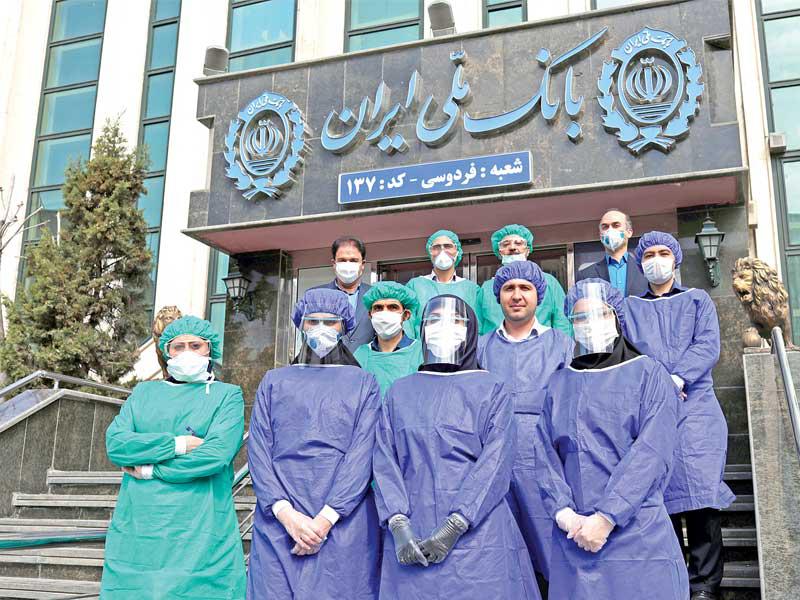 موظفو مصرف في طهران يرتدون ثياباً خاصة للوقاية من كوروناt(رويترز)