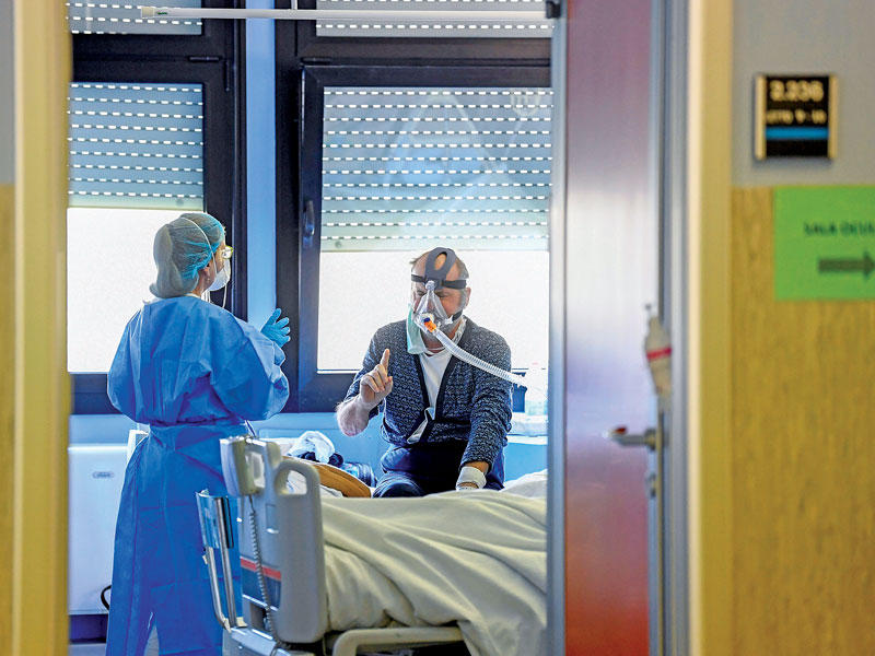 طبيبة إيطالية تتحدث مع مصاب بالفيروس في مستشفى كريمونا أمس (رويترز)n