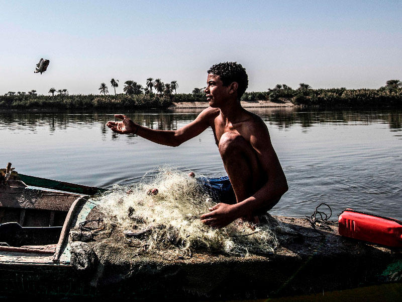 مصري يصطاد البلطي من نهر النيل قبالة جبل الطير شمال المنيا (أ ف ب)n