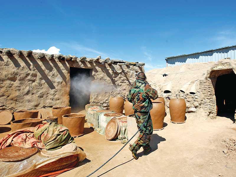 عسكري عراقي يعقم مصنعاً منزلياً في النجف أمس    (رويترز)