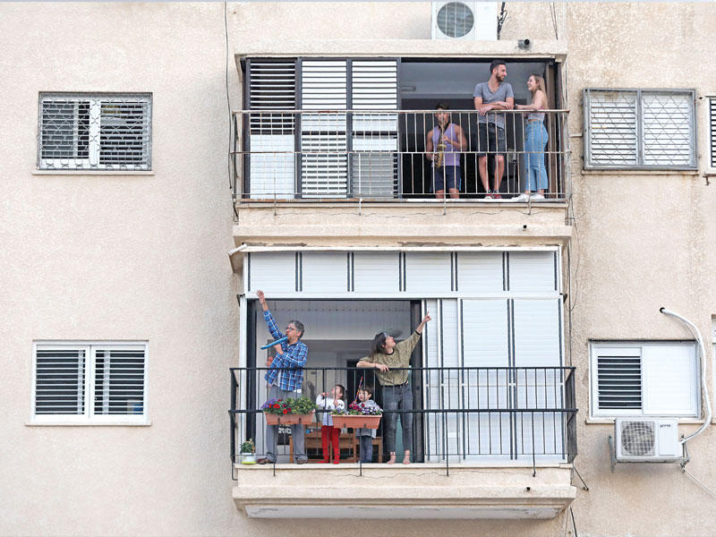 إسرائيليون في الشرفات بتل أبيب بسبب منع التجول (أي بي أيه)