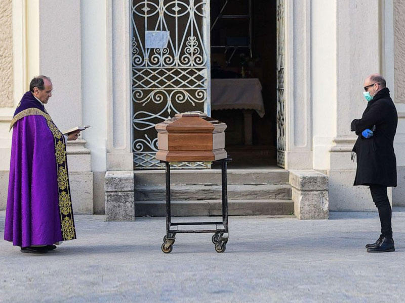 كاهن يصلي على أحد ضحايا الفيروس في إيطاليا
