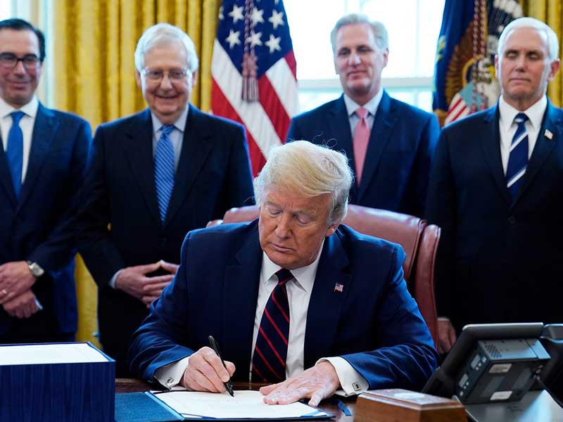 الرئيس الامريكي دونالد ترامب خلال توقيعه على حزمة الدعم لمواجهة فيروس كورونا
