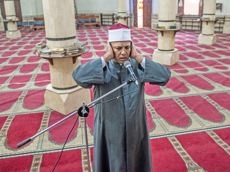 مؤذن مصري يرفع الأذان بلا مصلين في أحد مساجد القاهرة  أمس الأول  (إي بي أيه)