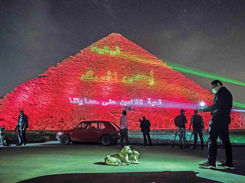هرم خوفو وعليه رسالة ضوئية تدعو المصريين للبقاء في منازلهم (أ ف ب)