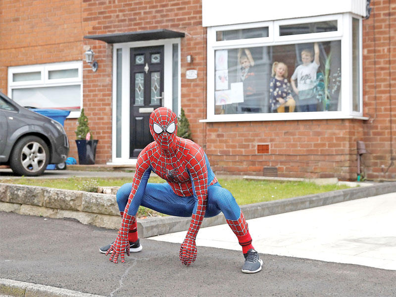 البريطاني جايسون بيرد بزي سبايدرمان خلال مهمته اليومية التي يقوم بها بمبادرة شخصية للترويح عن الأطفال داخل منازلهم في ستكوبرت أمس (رويترز)