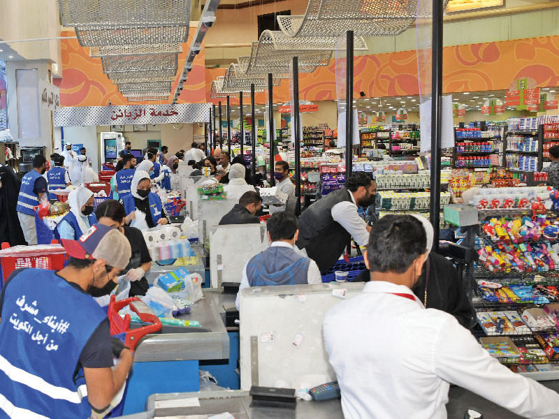 المتطوعون خلال عملهم في تعبئة الأغراض عقب قرار «التجارة» منع عمالة المناولة               (تصوير ميلاد غالي)