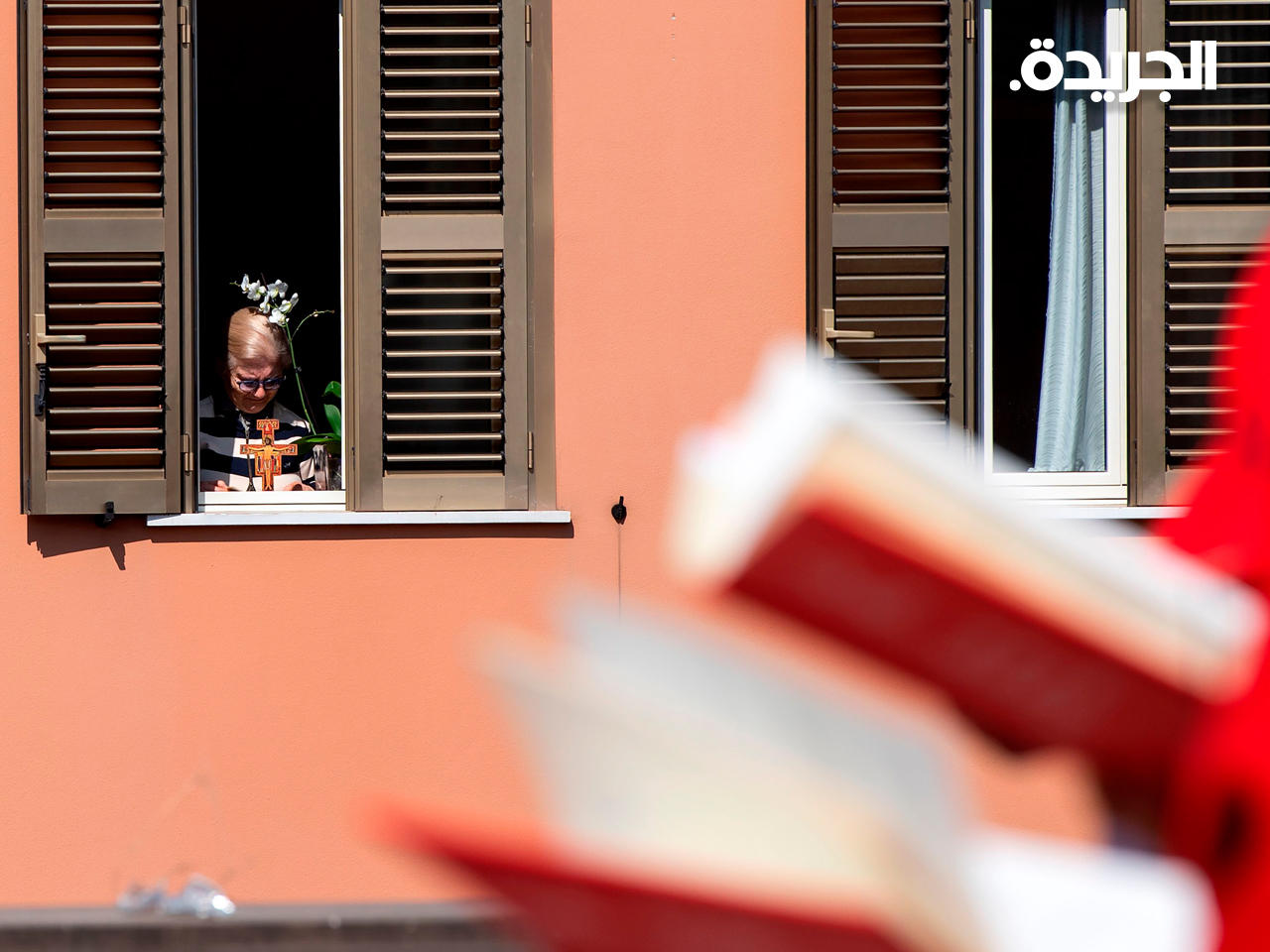 إيطالية تستمع لقداس الأحد من شرفة المنزل في روما