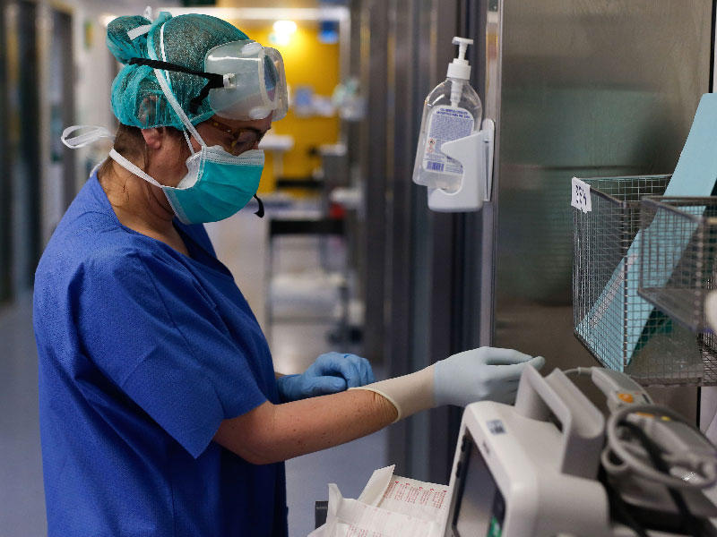 عامل رعاية صحية يرتدي بدلة واقية  في وحدة العناية المركزة  بمستشفى فال ديبرون في برشلونة