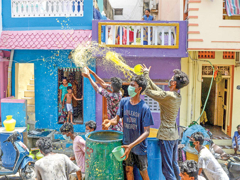 هنود يرشون مياهاً ملونة تحوي مواد طبية لقناعتهم بأنها تحمي من الفيروس في شيناي أمس (ا ف ب)