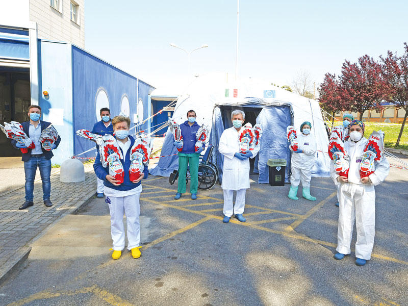 عاملون صحيون يحملون «بيض العيد» في روما مع اقتراب الفصح المسيحي (رويترز)