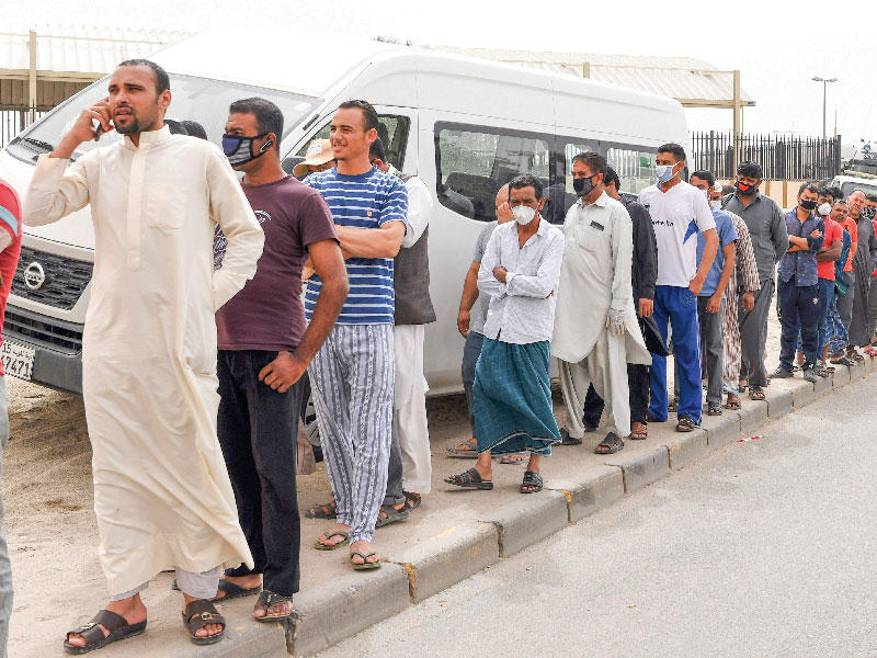 طابور من العمالة في جليب الشيوخ بانتظار توزيع الخبز       (تصوير عبدالله الخلف)