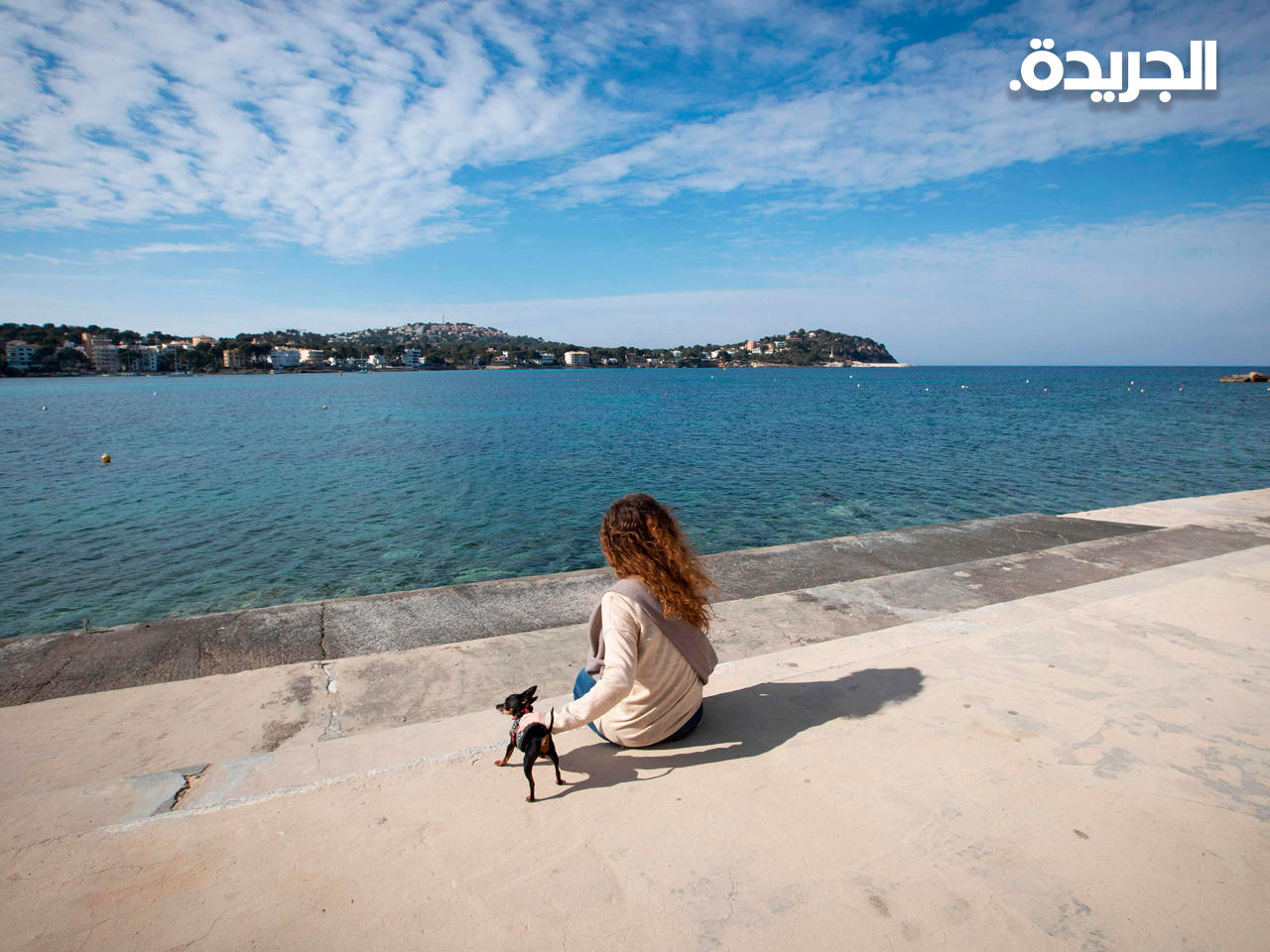 امرأة مع كلبها على شاطئ سانتا بونكا الفارغ