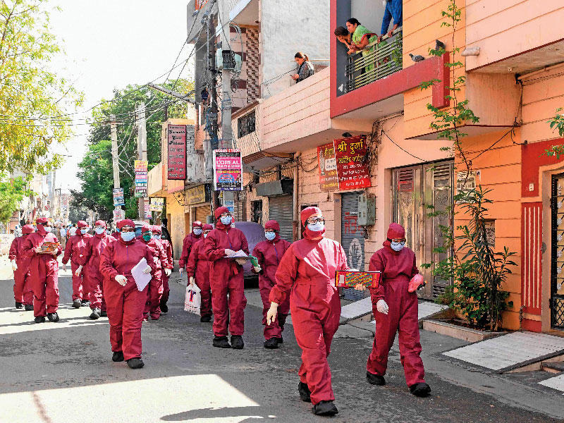 عاملون صحيون يتفقدون الإجراءات في حي سكني بامريتسار في الهند أمس (أ ف ب)n