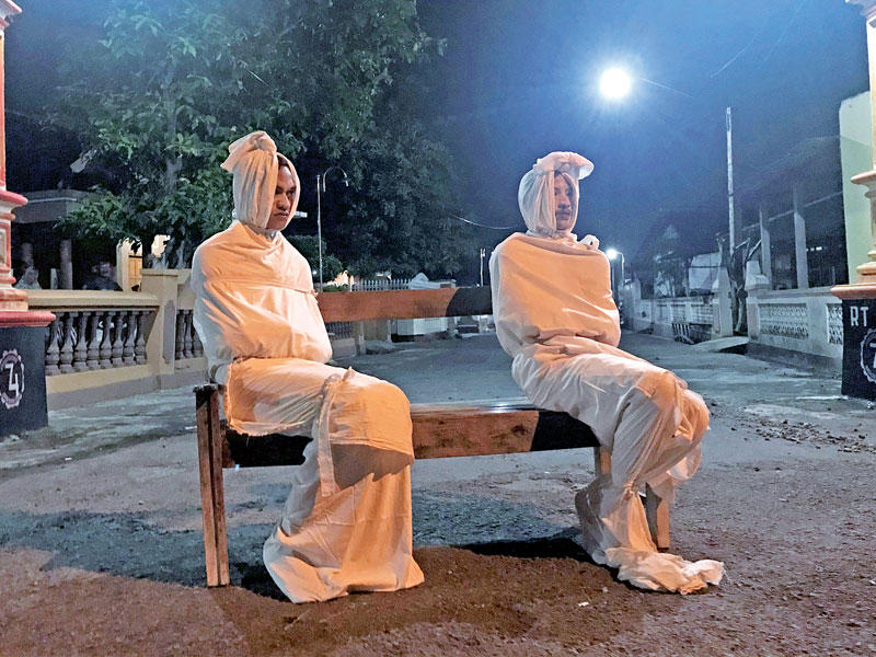 متطوّعان من «بوكونغ» بانتظار خارقي الحجر المنزلي (رويترز)