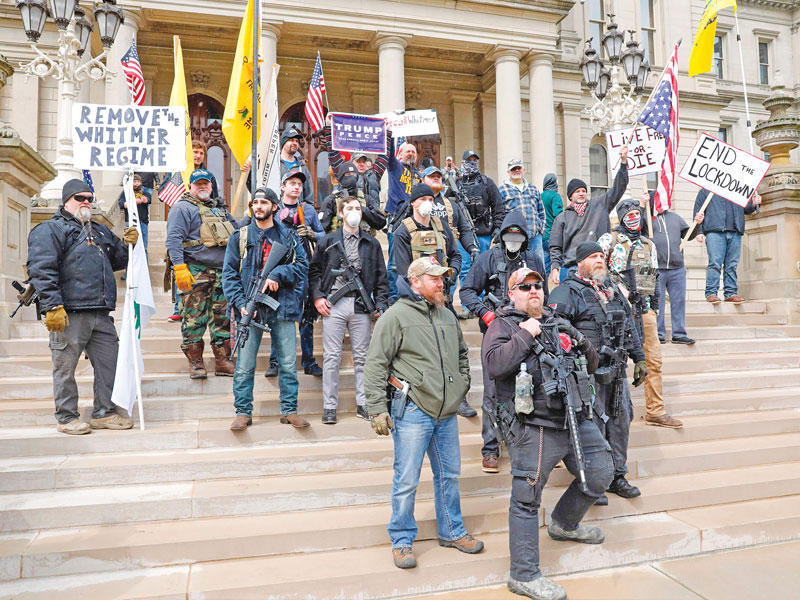 أميركيون يتظاهرون بكامل أسلحتهم في ميشيغان ضد إجراءات العزل في ولايتهم أمس الأول t(أ ف ب) 