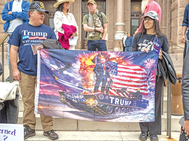 أميركيان مؤيدان لترامب خلال تظاهرة ضد العزل أمام مقر ولاية تكساس في أوستن أمس الأول (رويترز) 