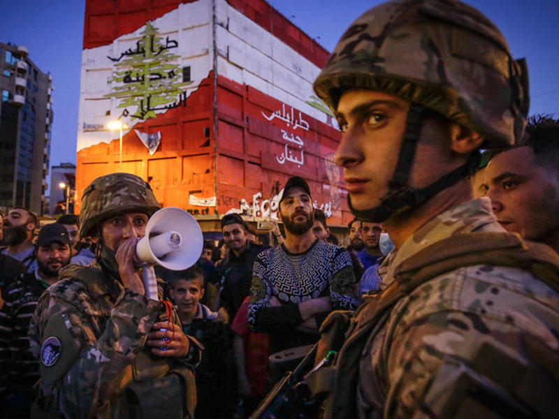 عناصر من الجيش اللبناني يحافظون علي الأمن في مظاهرات ضد الغلاء في مدينة طرابلس الشمالية علي الرغم من غغلاق البلاد بسبب فيروس كورونا (AFP)
