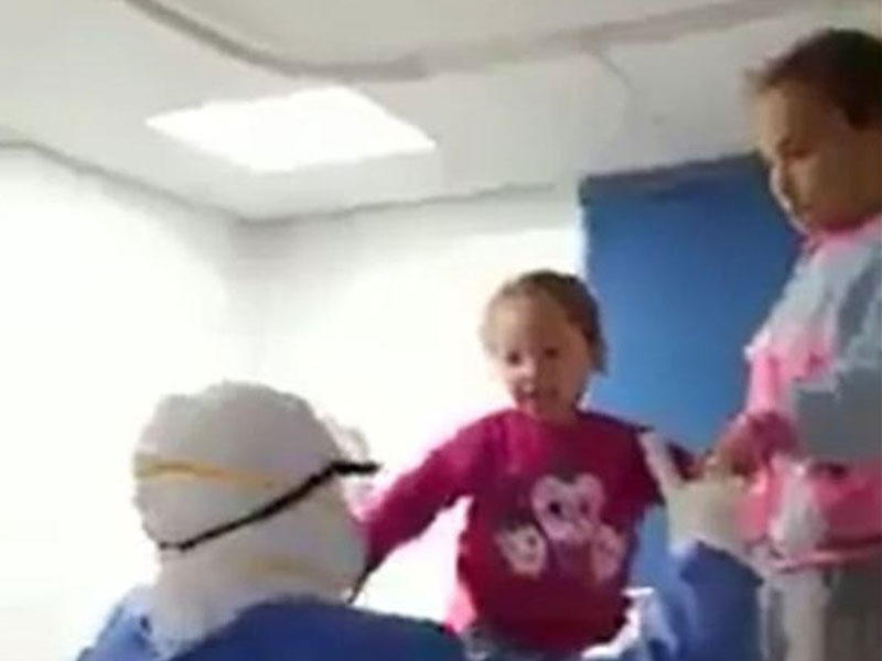 لقطة من الفيديو المتداول فيه إحدى الممرضات بمستشفى الحجر الصحي وهي تداعب طفلين مصابين بفيروس كورونا في مستشفى العزل في قها التابعة لمحافظة القليوبية