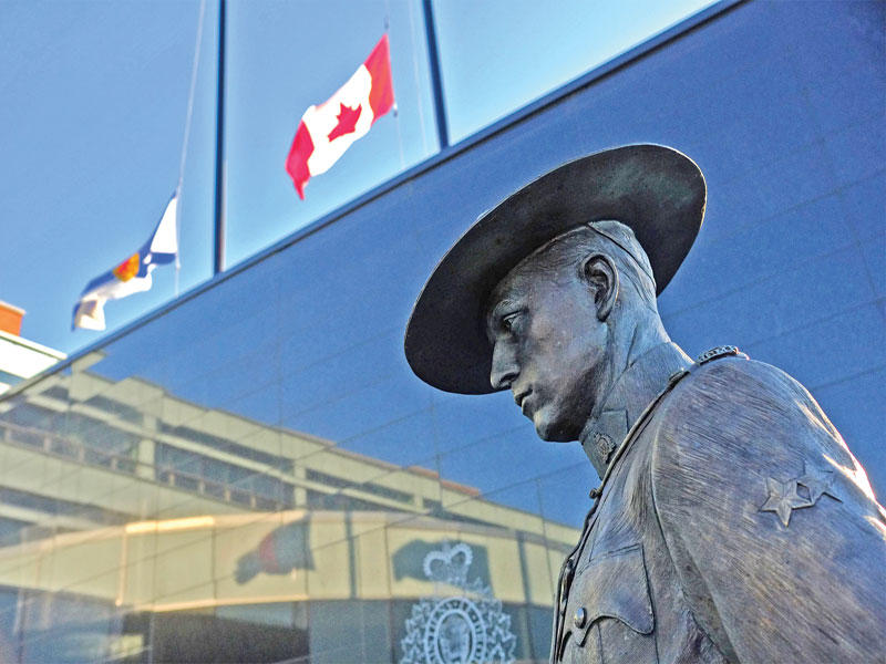 تنكيس أعلام مقاطعة نوفا سكوتيا وكندا فوق مقر شرطة المقاطعة حداداً على ضحايا إطلاق النار  (أ ف ب )