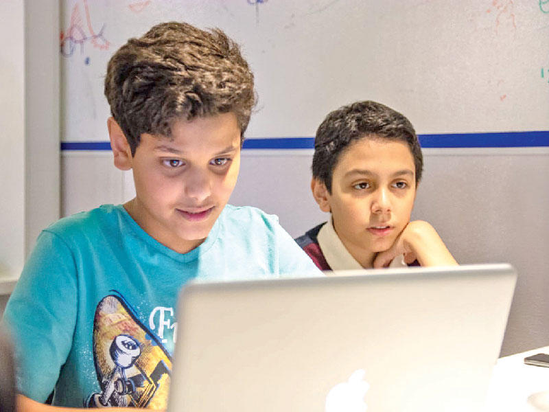 فتيان يتابعان أحد برامج «لوياك»