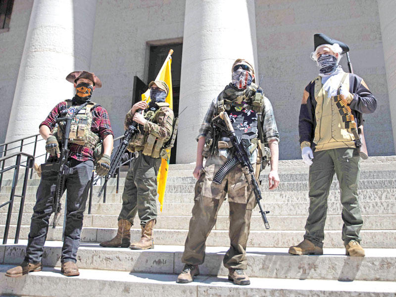 أميركيون مسلحون أعضاء في ميليشيا محلية يرتدون أزياء تقليدية على درج مقر ولاية اوهايو بكولومبوس عاصمة الولاية  أمس الأول (أ ف ب )