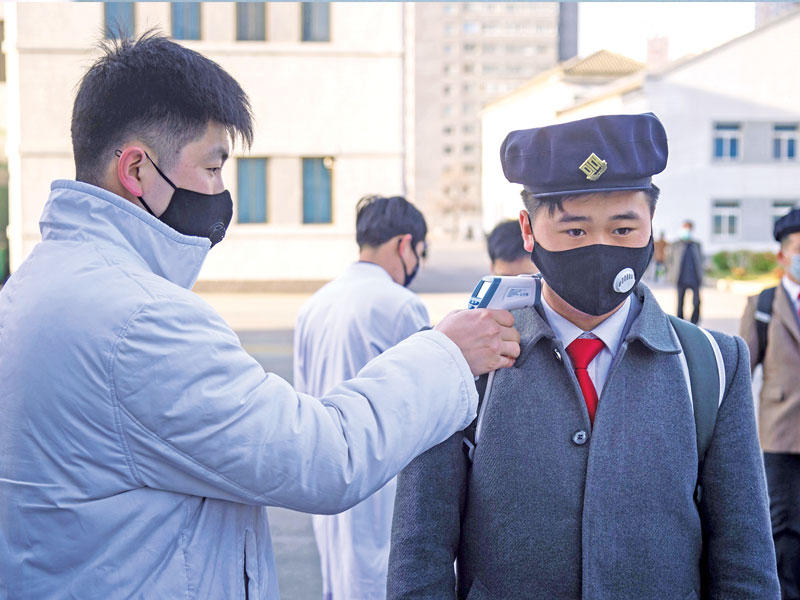 طالب كوري شمالي يخضع للفحص قبل مشاركته في ندوة حول إجراءات الوقاية من «كورونا» في جامعة بيونغ يانغ للطب أمس الأول (أ ف ب)