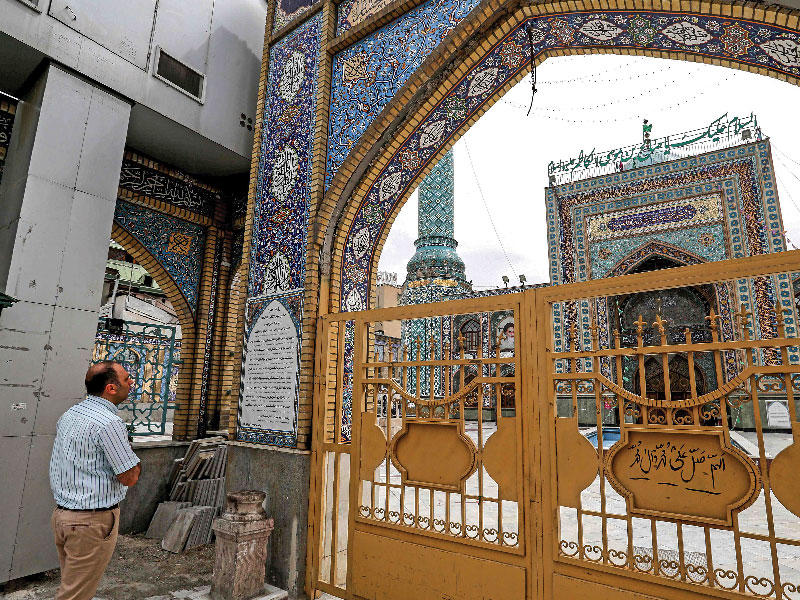 إيراني يبتهل على بوابة أحد مساجد طهران المغلقة بسبب كورونا أمس (أ ف ب)