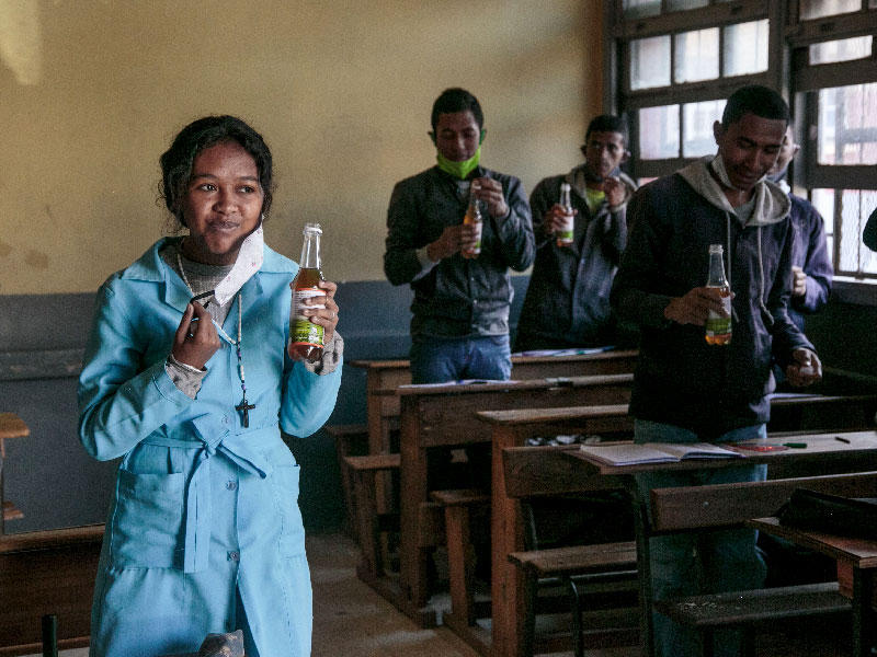 يشرب الطلاب من زجاجات شاي عشبي ، يروج له رئيس مدغشقر أندري راجولينا كعلاج قوي ضد فيروس كورونا