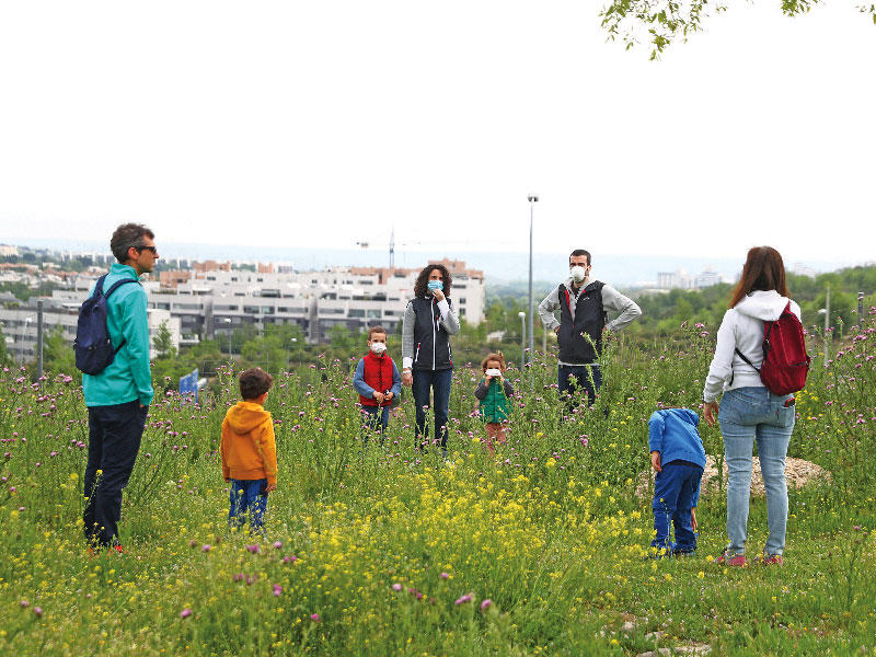 أسبان يخرجون أطفالهم إلى إحدى حدائق مدريد أمس مع رفع جزئي للقيود عن تحركات العائلات            (رويترز)