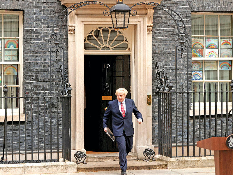 جونسون يخرج من مقره في 10 داونينغ ستريت لإلقاء أول كلمة بعد عودته إلى القيادة (رويترز)