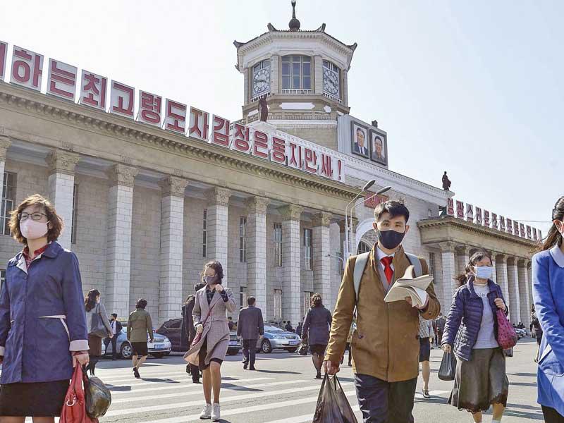 كوريون شماليون أمام محطة قطارات بيونغ يانغ أمس الأول (كيودو)