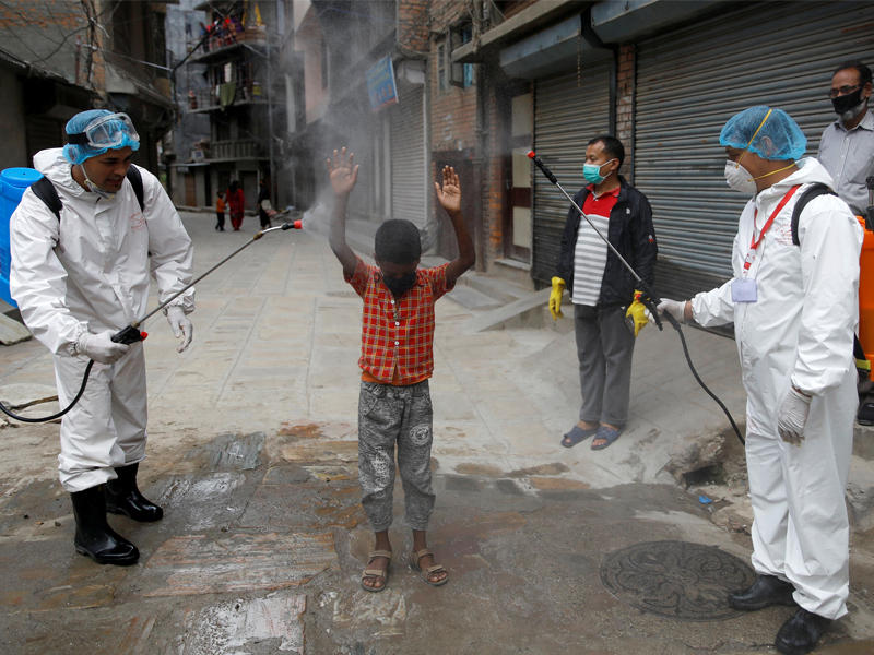 تعقيم طفل نيبالي في إحدى مناطق كاتموندو أمس (رويترز)